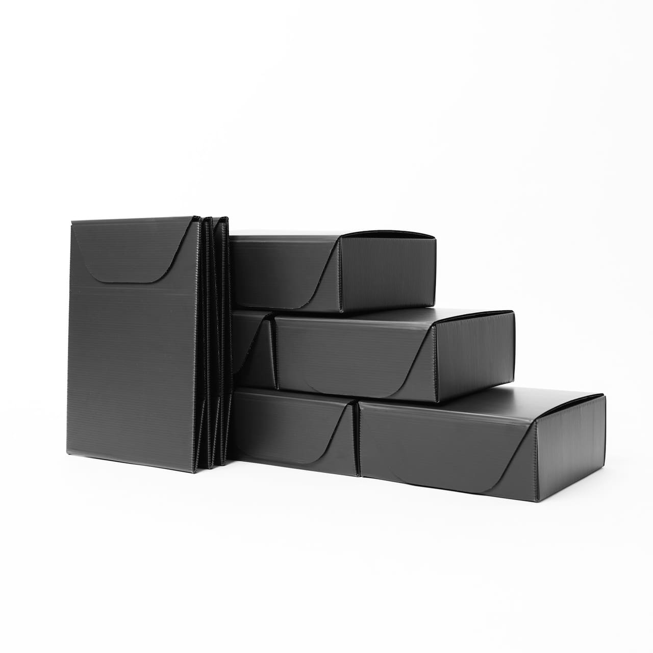 Black reusable shipping packs, folded flat and stacked, on white